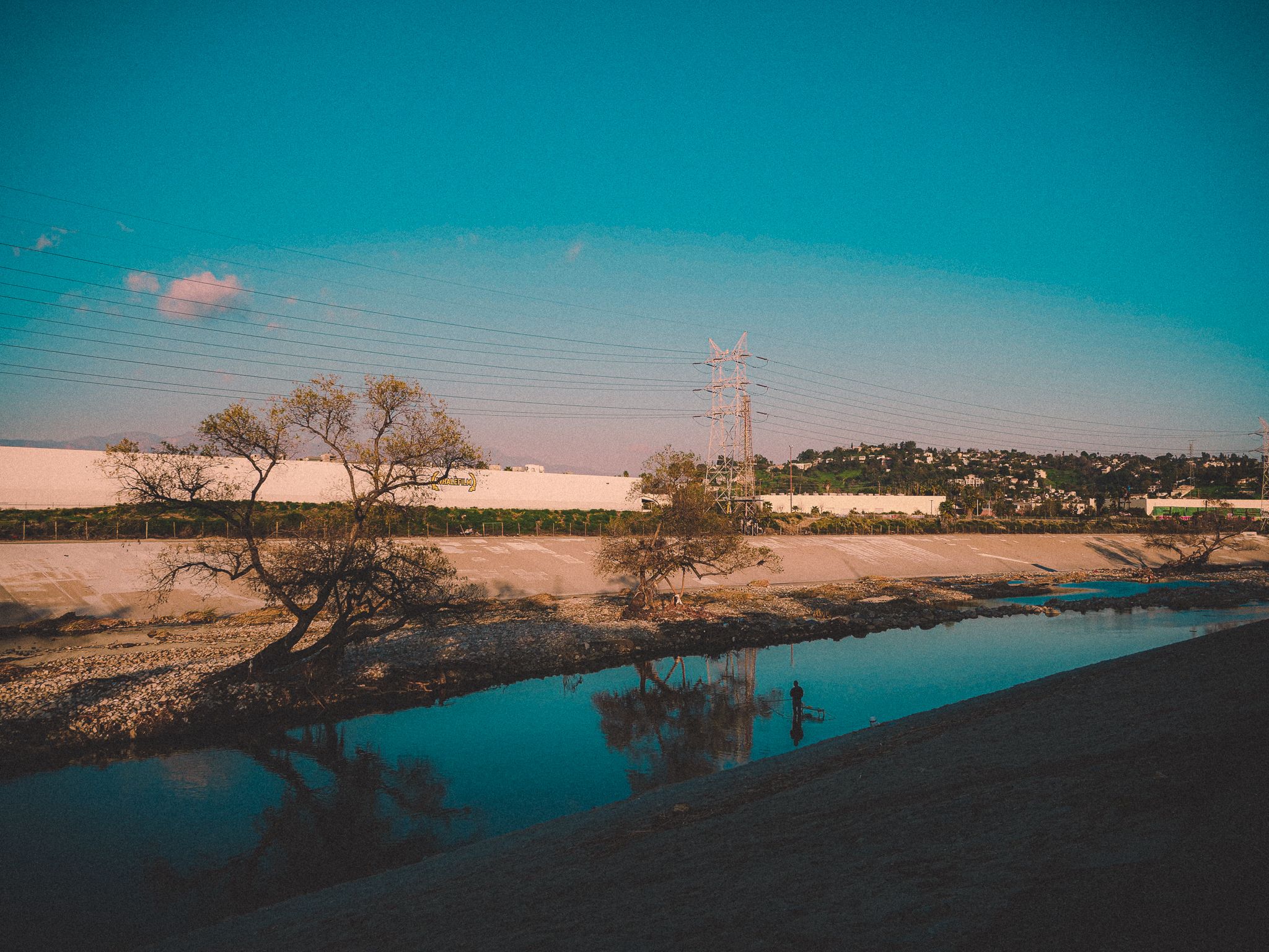 Man standing in the L.A. River and fishing
