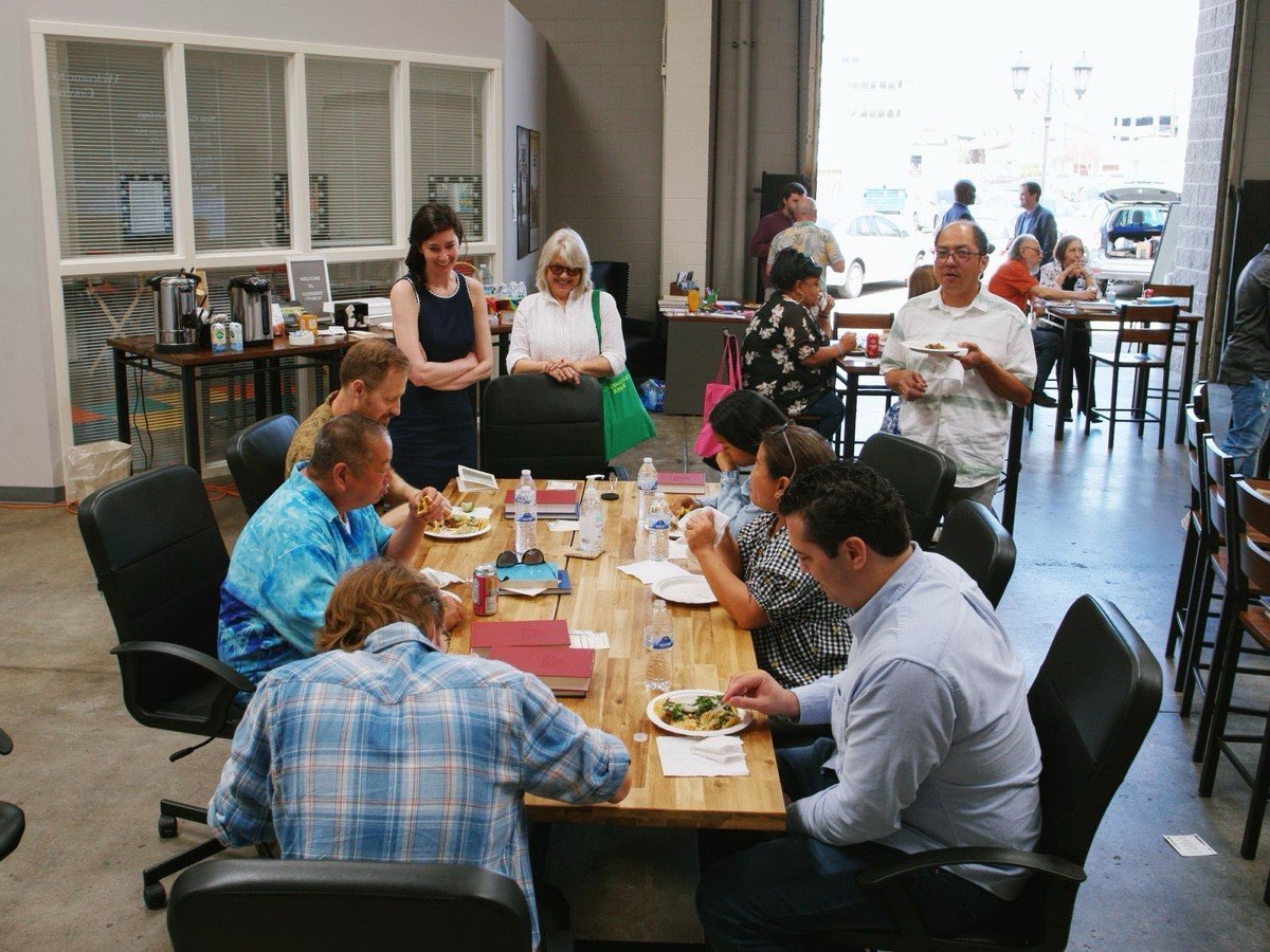 People of Covenant Church sharing a meal and conversation around a long table after Sunday worship in Burbank.